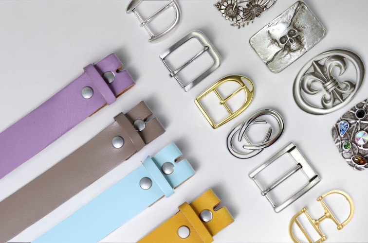 Gürtelschnallen aus Messing, Edelstahl und Silber neben farbigen Wechselgürteln aus Leder – Fronhofer Manufaktur