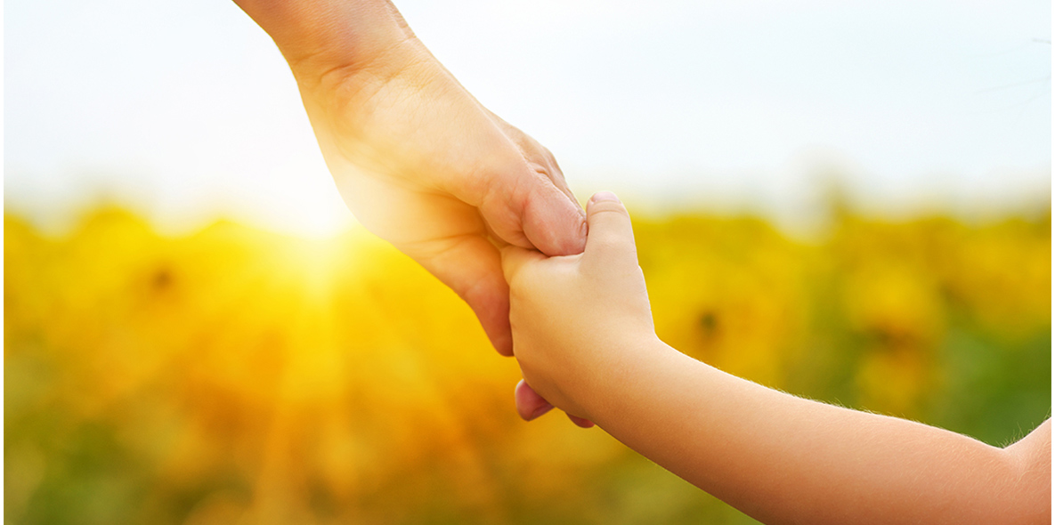Eine Kinderhand und eine erwachsene Hand, die sich halten.