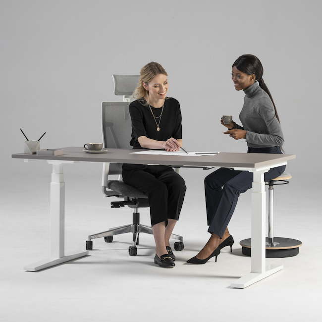 Zwei Frauen sitzen zusammen am Schreibtisch