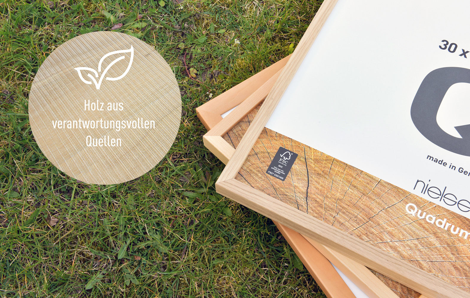 Ecke eines Holz-Bilderrahmens von Nielsen, liegend im grünen Rasen – Hinweis auf Holz aus verantwortungsvollen, FSC®-zertifizierten Quellen