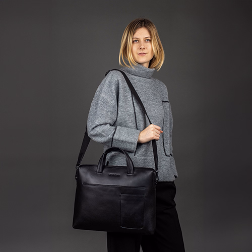 FEYNSINN Laptoptasche ENNo schwarz Leder Indoor Frau traegt schwarze Hose und grauen Pulli