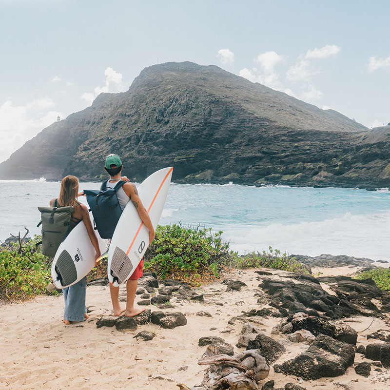 Surfer am Meer mit Rolltop Rucksack