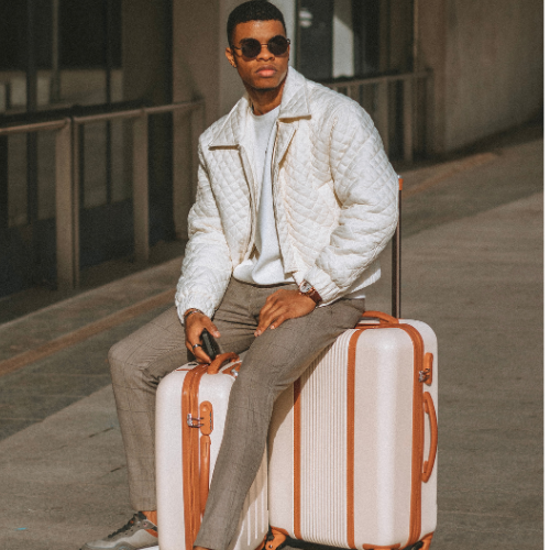 Ferge Koffer Milano beige braun Outdoor Mann sitzt auf dem Koffer