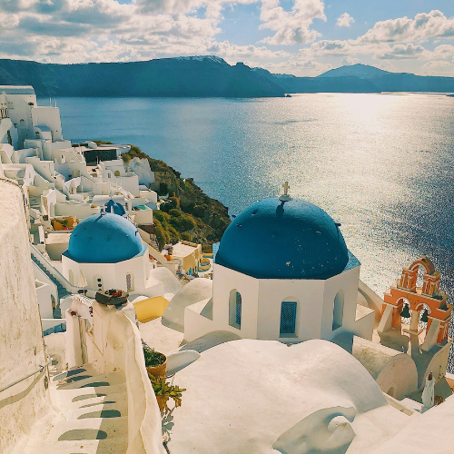 Landschaftsbild Santorini Griechenland blaue Daecher und blaues Meer