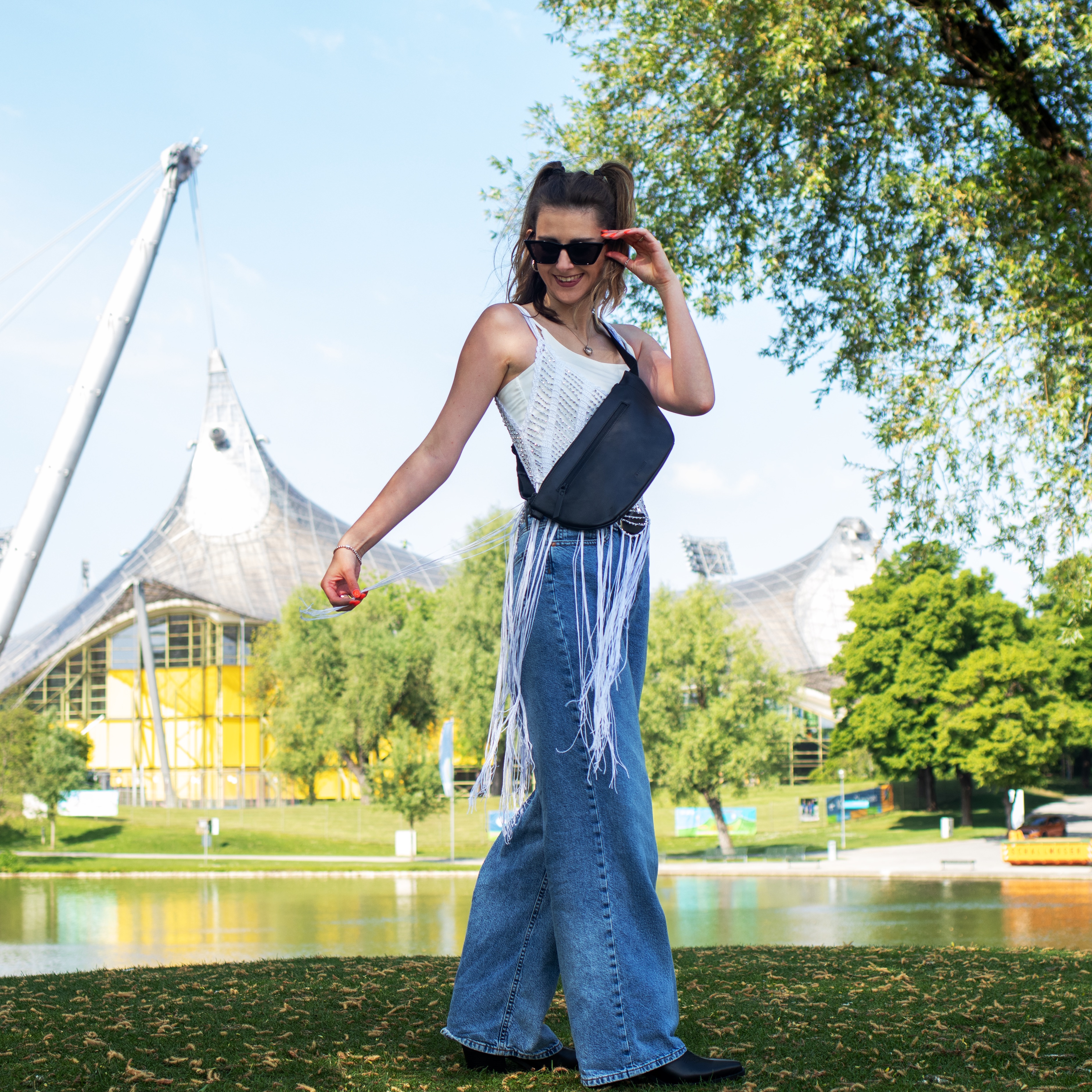 FEYNSINN Bauchtasche Leder schwarz Festival Outdoor Frau traegt Fransentop mit einer weiten Jeans