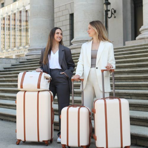 Ferge vierteiliges Kofferset in beige zwei Frauen tragen Hosenanzug