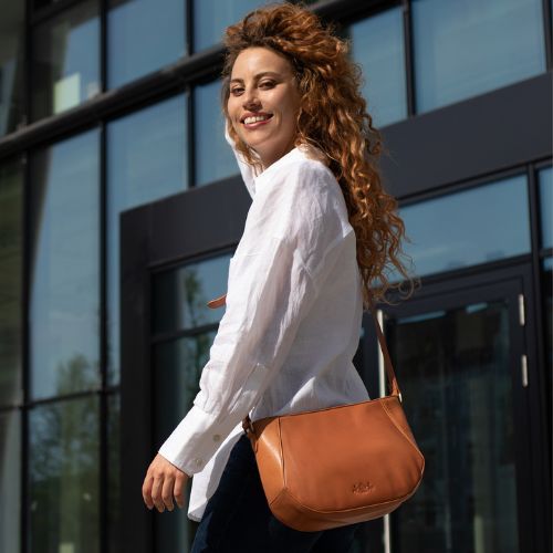 Sid & Vain Umhängetasche hellbraun Leder Outdoor Frau traegt eine weiße weite Bluse