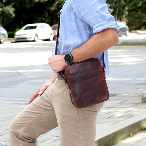 Sid & Vain Umhängetasche Herren Leder Outdoor Mann traegt ein blaues Hemd und eine beige Hose