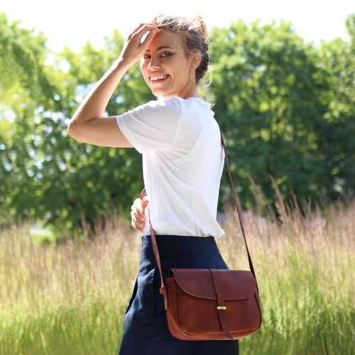 Sid & Vain Umhängetasche Leder Outdoor Frau traegt weite weiße Bluse und eine blaue weite Hose