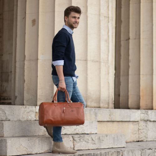 Sid & Vain Weekender leder hellbraun für Herren Outdoor Mann steht auf Treppen und traegt eine Jeans und blauen Pulli
