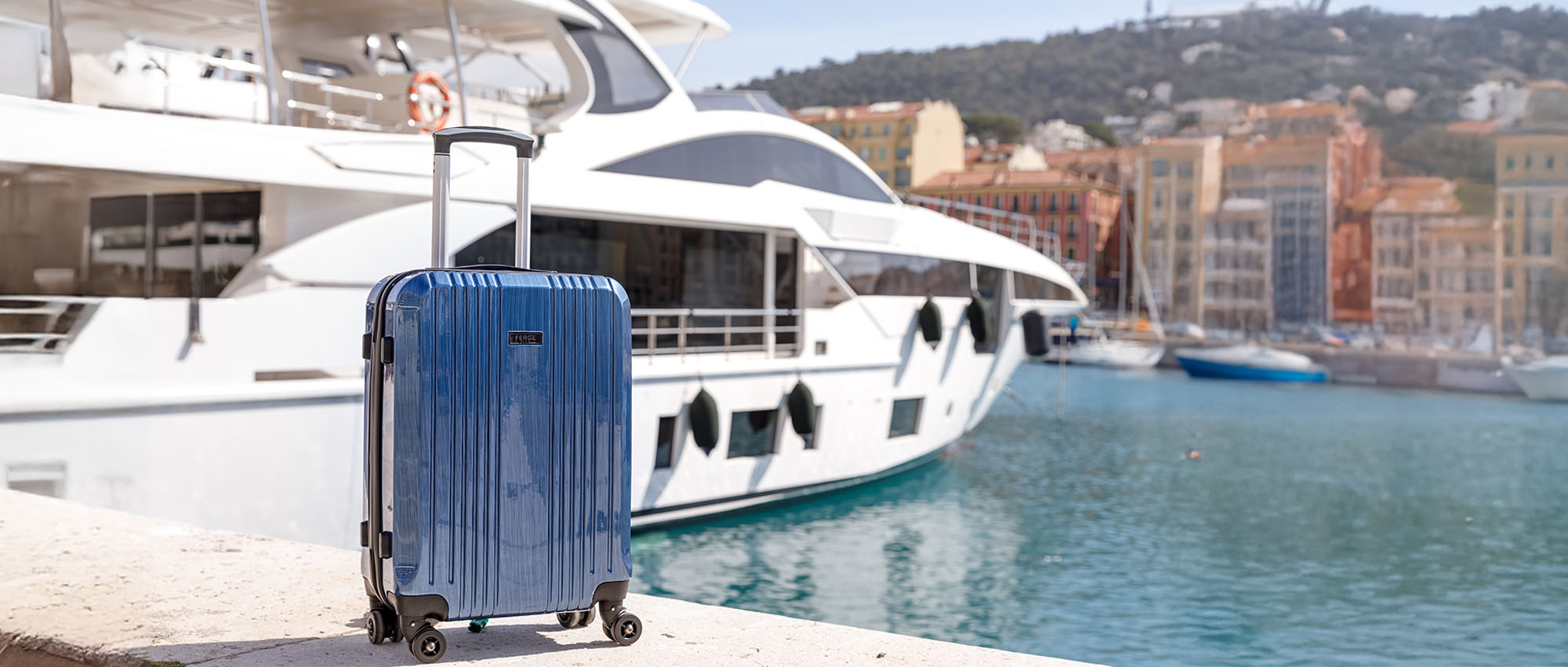 Carry-on suitcase made of PU and ABS in front of a yacht