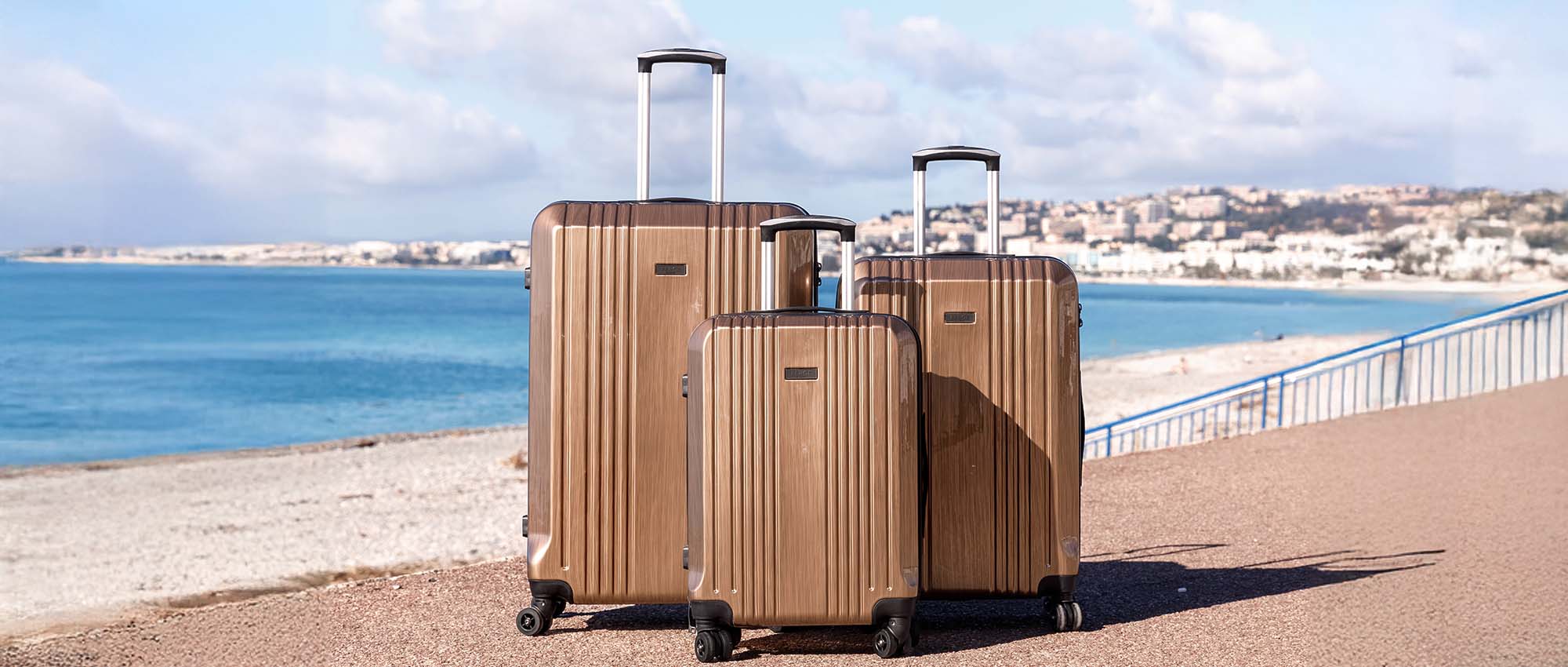 Luggage set consisting of 3 suitcases made of PU and ABS in front of the coast