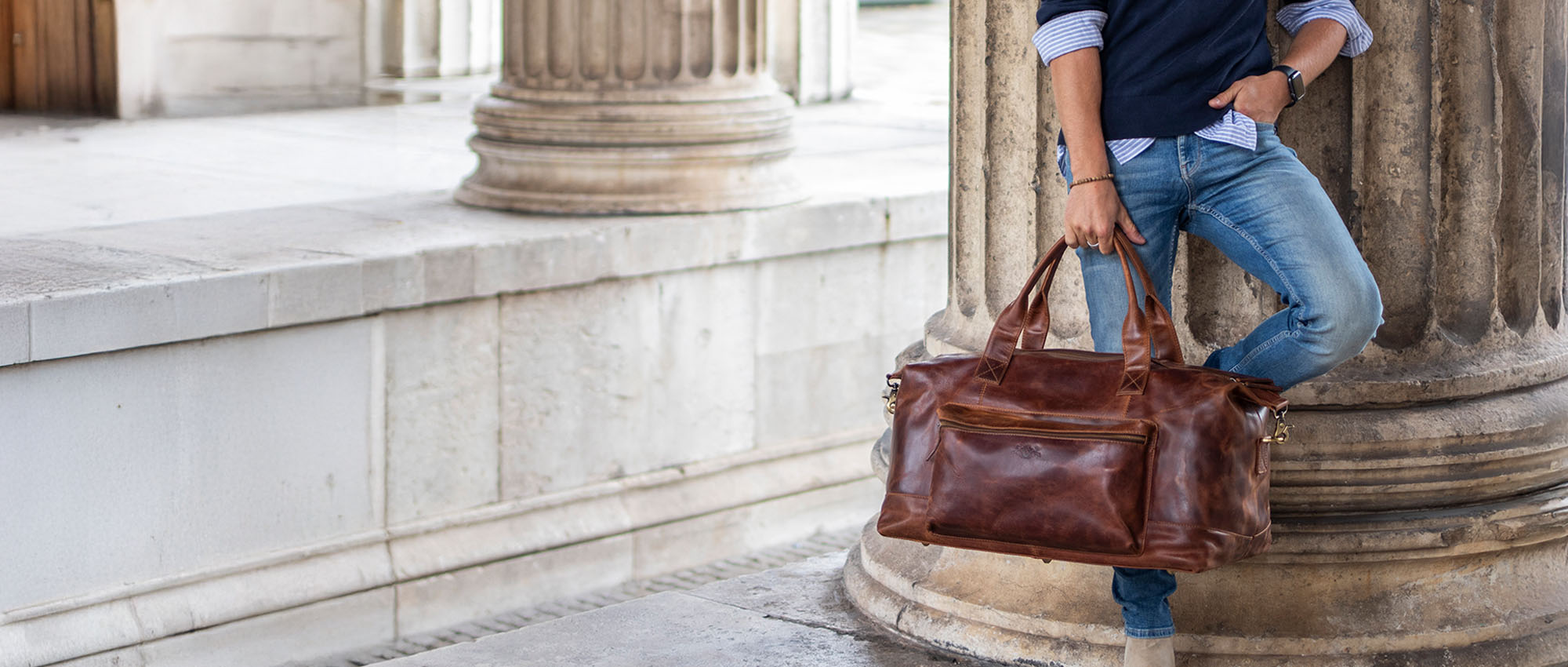 Men's leather travel bag in the hand of a student