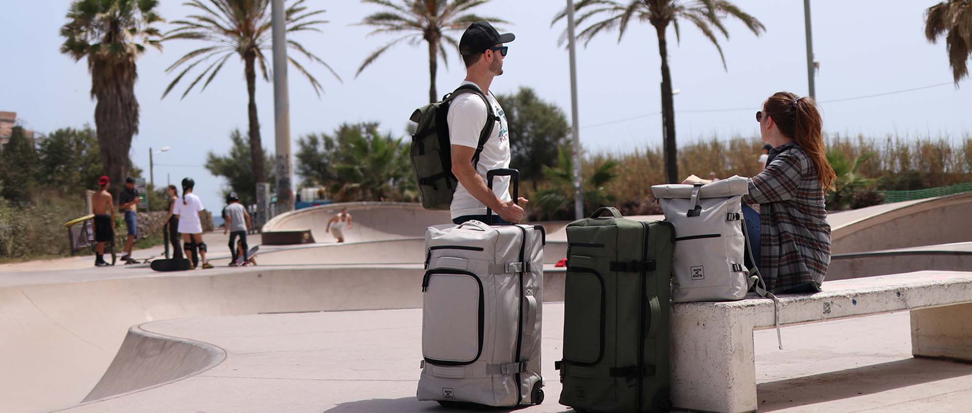 wheeled duffle XL bag next to a woman and a man at the skatepark