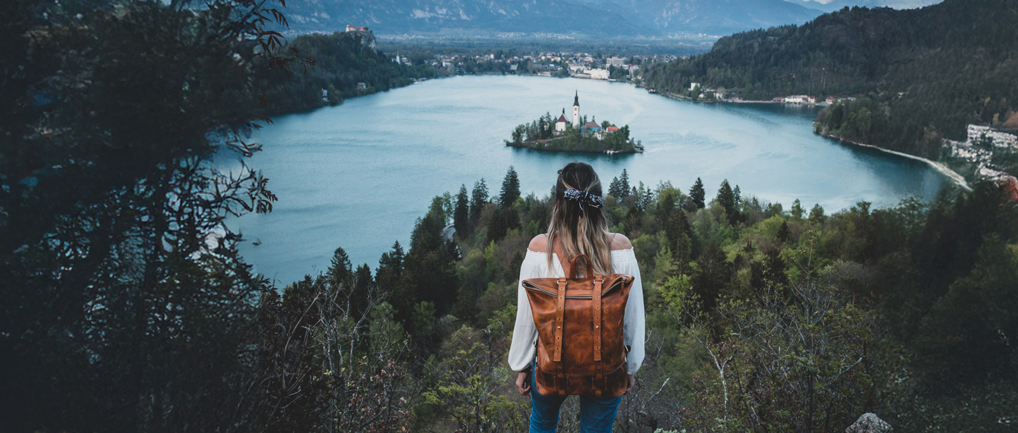 Rolltop Rucksack Damen auf Rücken von Frau auf einer Klipp mit Blick auf See