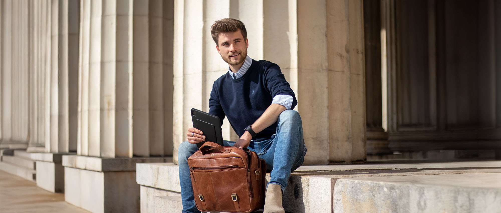 Sac de travail en cuir et homme assis en tenue smart casual