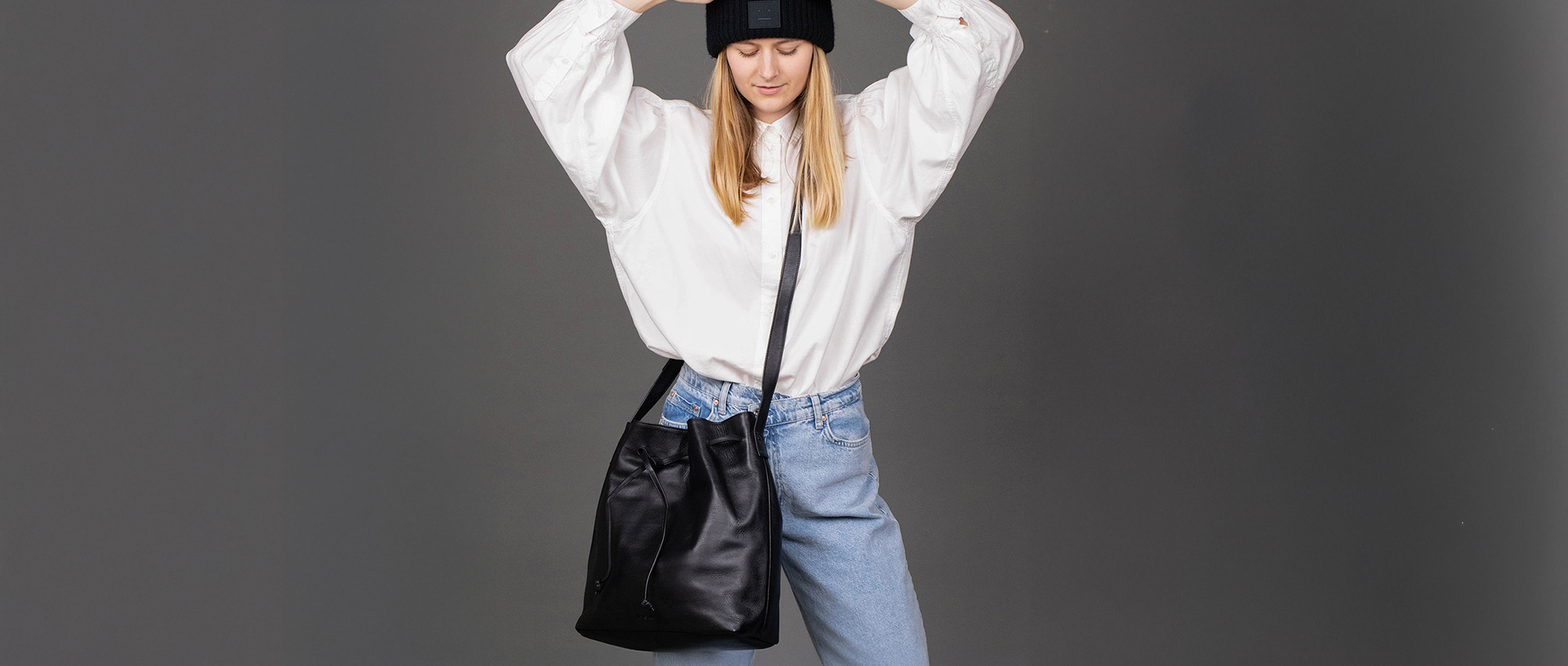 Leather bucket bag on a blonde woman in the studio