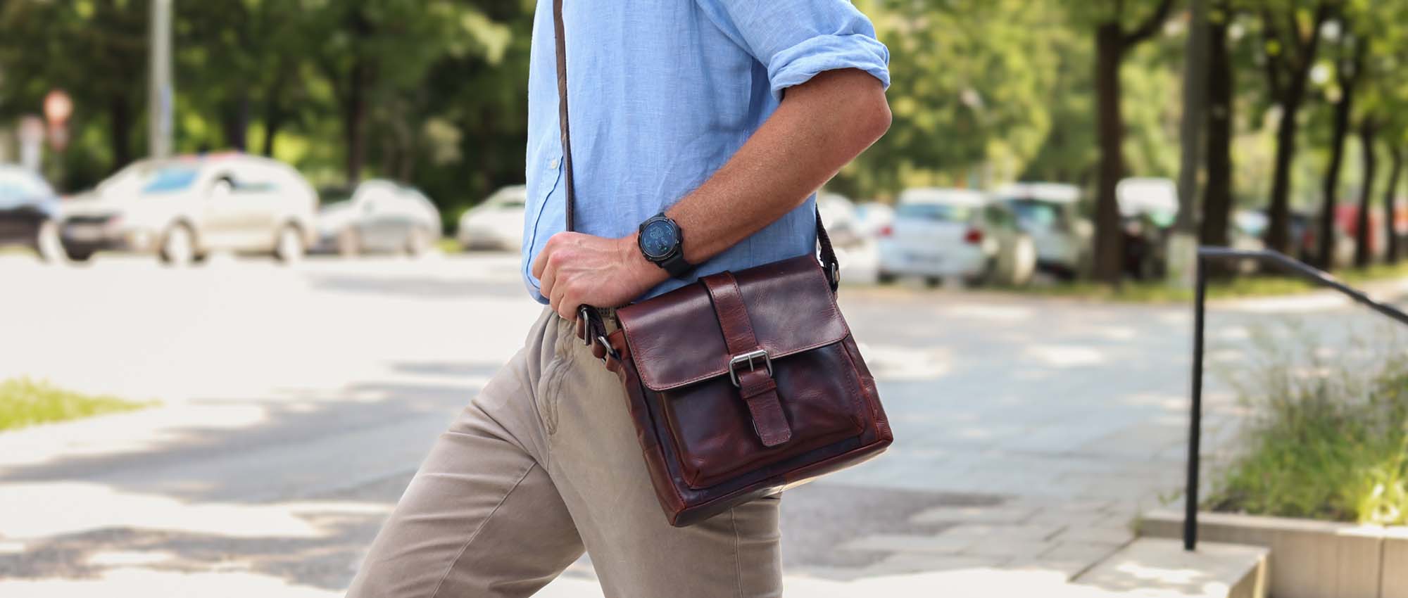 Brown leather crossbody bag on a man in a smart casual student outfit