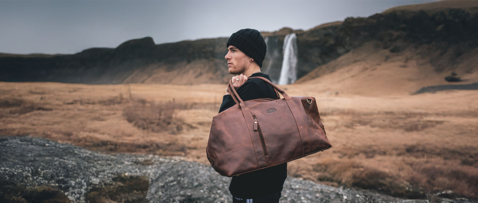 Leather weekender bag for women and men on a man traveling in Iceland