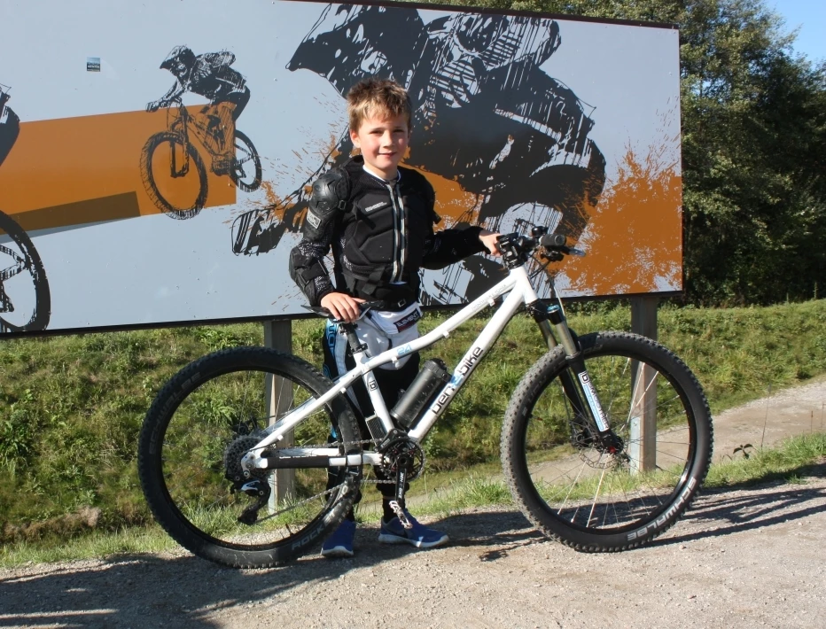 Ben mit dem E-Bike vor einem Schild