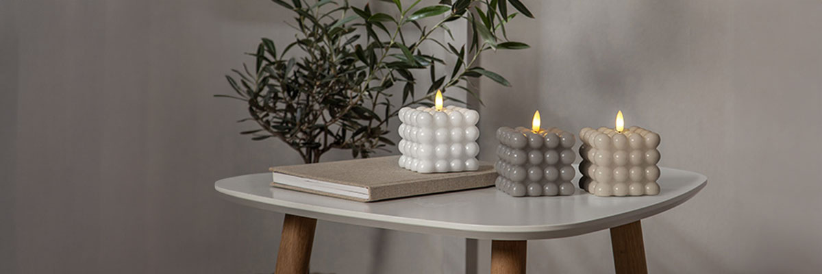 Drei Bubble Kerzen auf einen weißen Tisch. Bubble Kerze in weiß, grau und Beige.