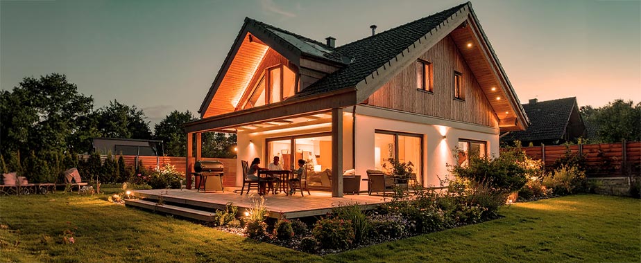 Freistehendes Einfamilienhaus mit beleuchtetem Garten am Abend