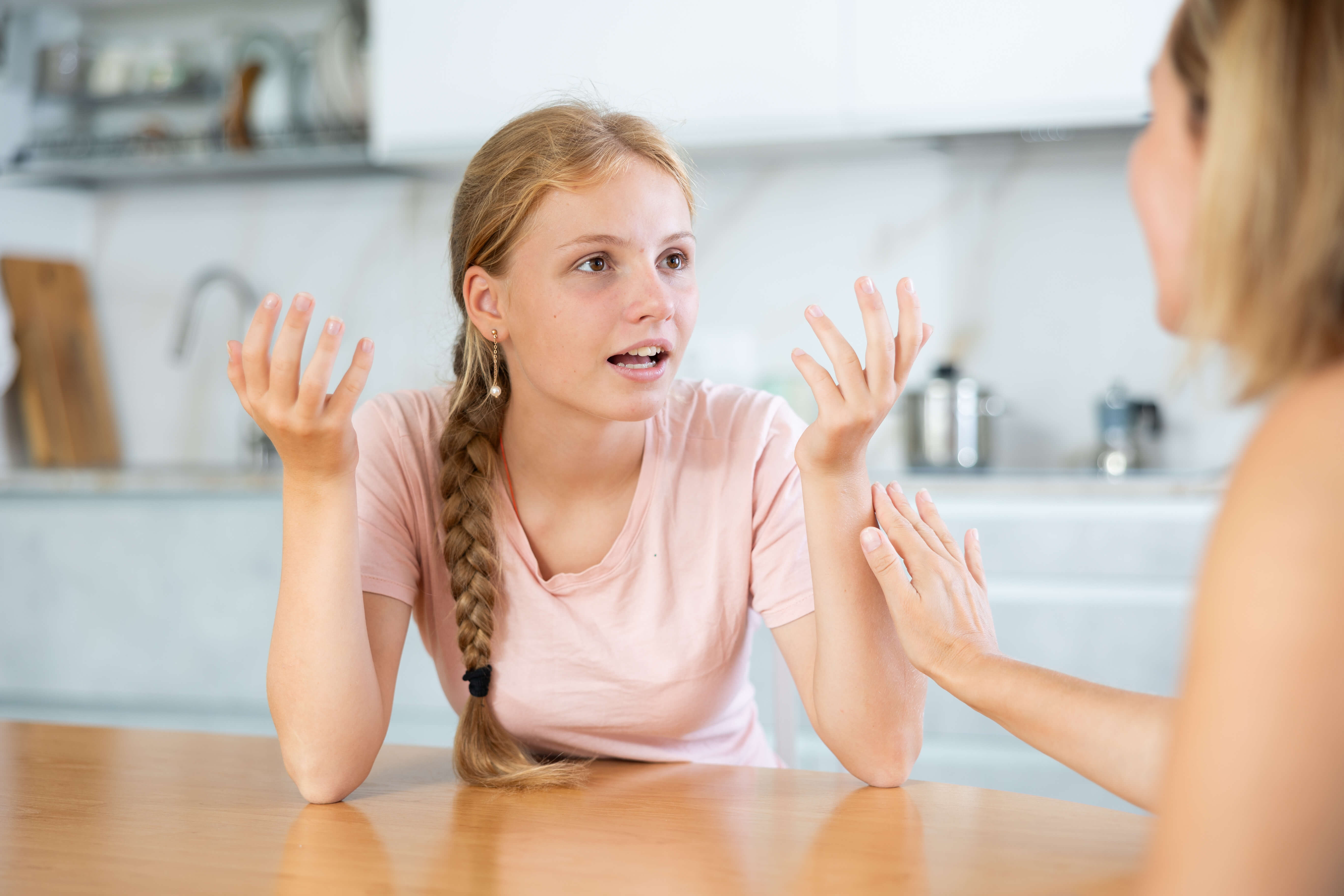 Mädchen im Ballettoutfit sitzt und spricht mit ihrer Mama
