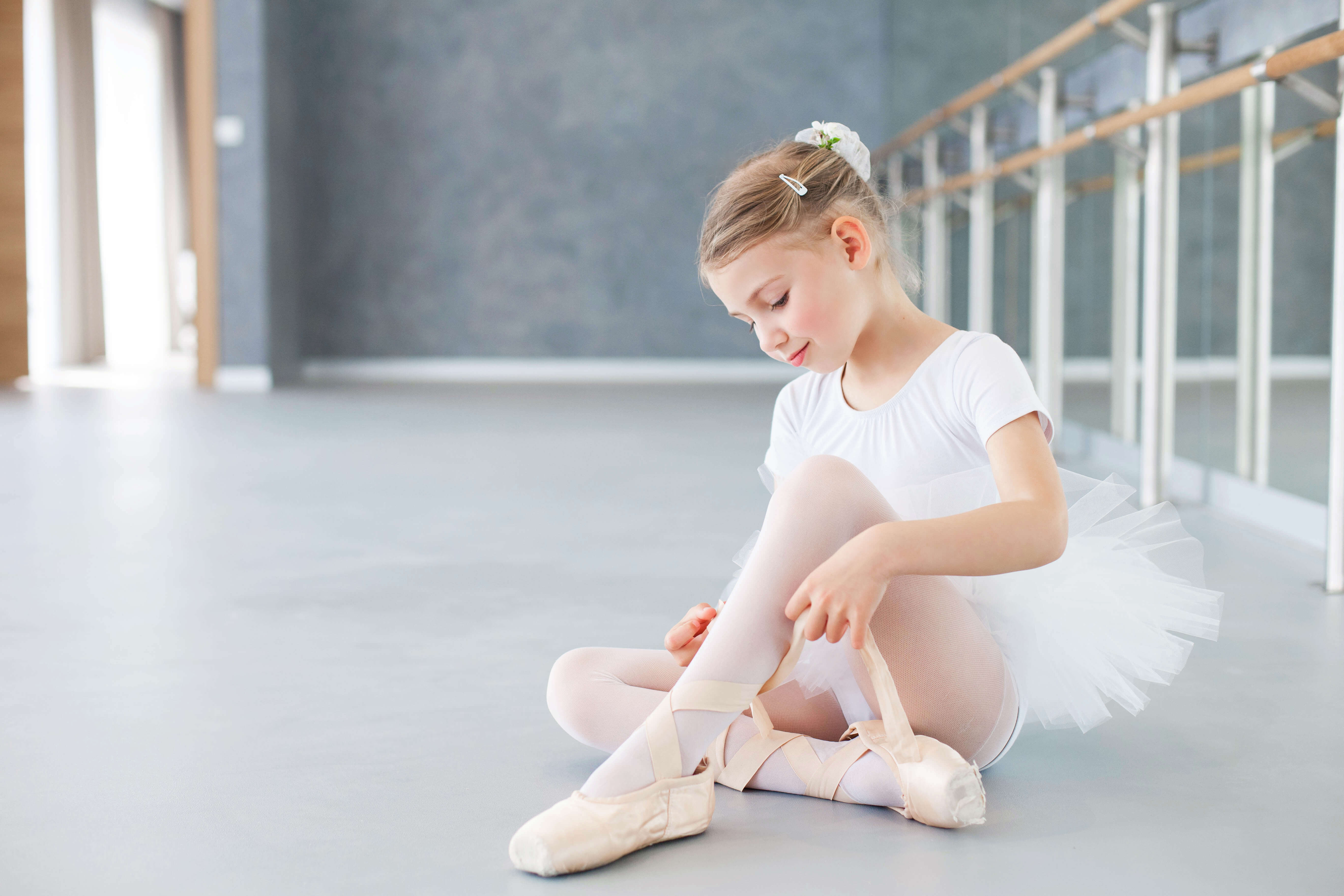 Kind schnürt konzentriert seine Ballettschuhe