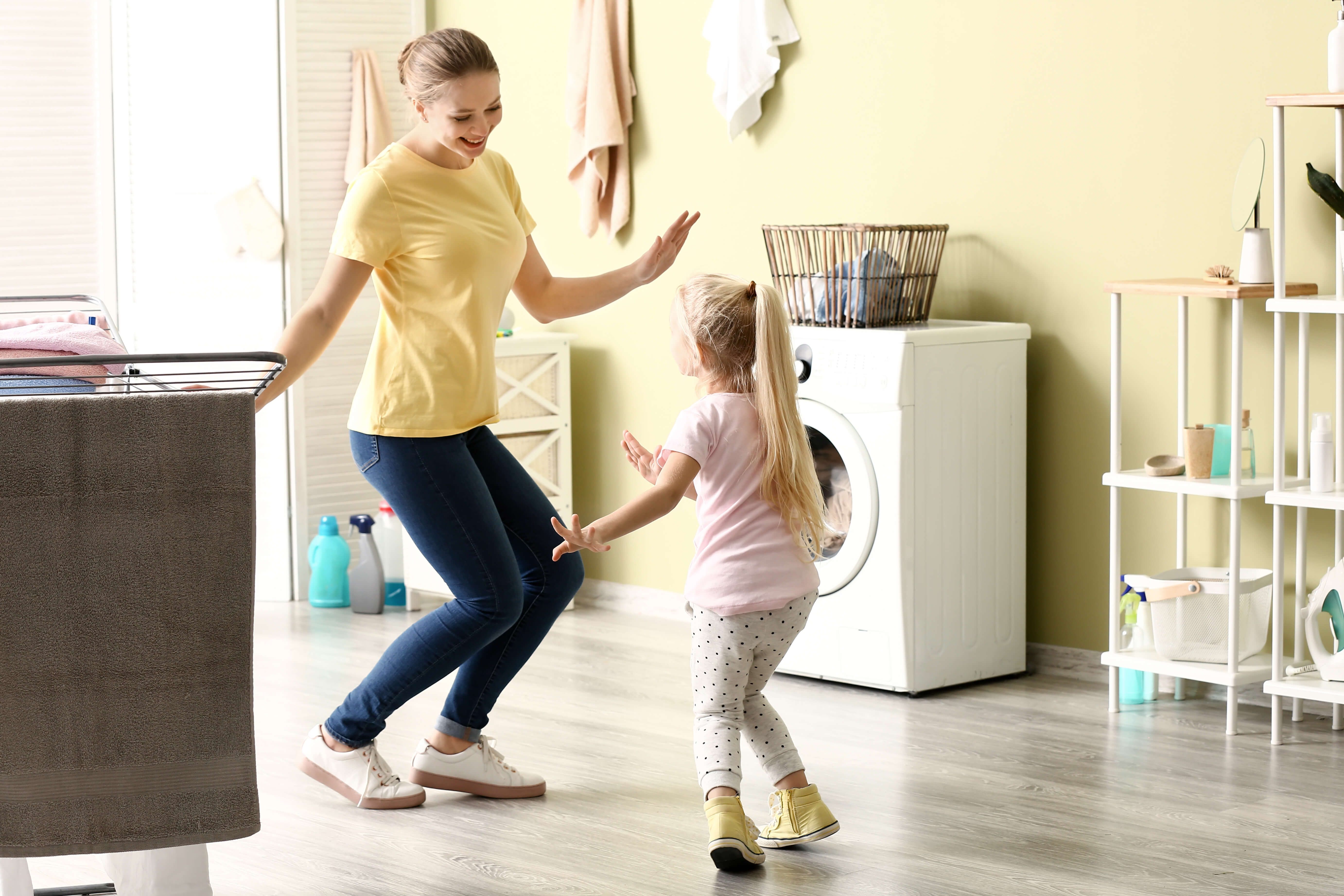 Kind tanzt mit Freude mit Mama zuhause