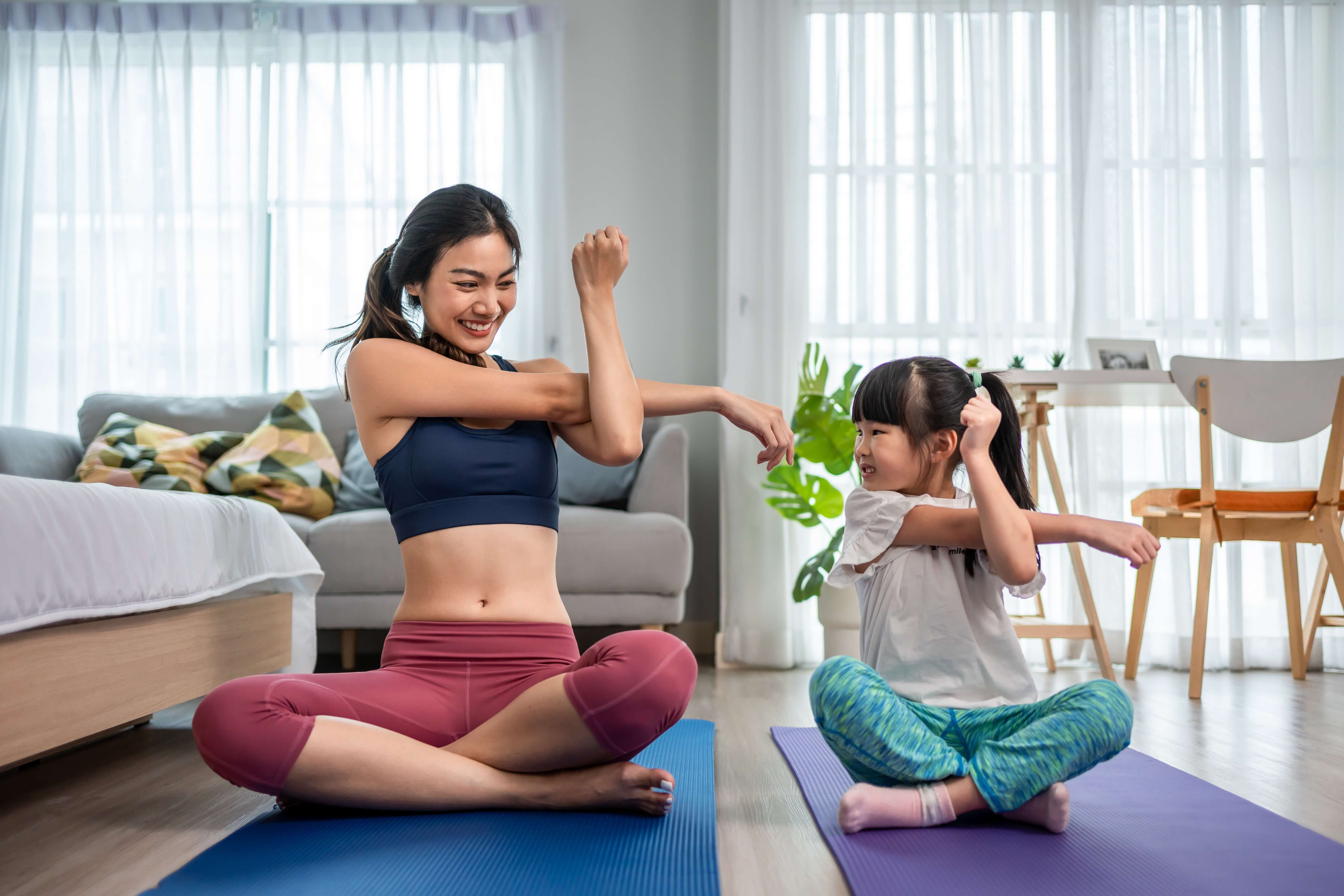 Mutter und Kind dehnen gemeinsam auf Matte