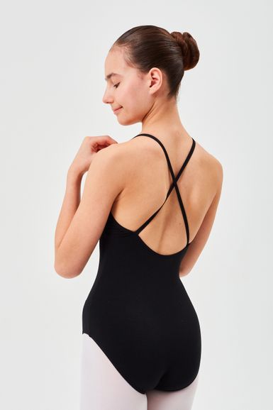 Eine Person in einem schwarzen Ballettanzug mit gekreuzten Trägern und weißen Strumpfhosen steht mit dem Rücken zur Kamera.