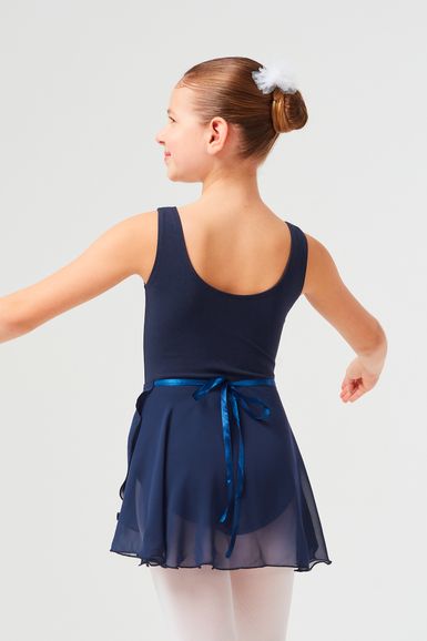 Junges Mädchen in einem marineblauen Ballettbody und Rock mit einer blauen Schleife