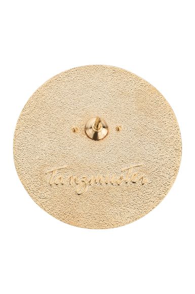 Ein strukturiertes goldenes Oval mit der Gravur „Tanzmeister“ und einem zentralen Stift zur Befestigung.