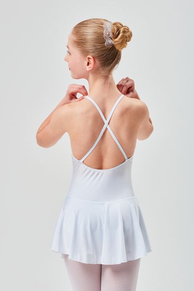 Ein junges Mädchen in einem weißen Ballettkleid steht mit dem Rücken zur Kamera