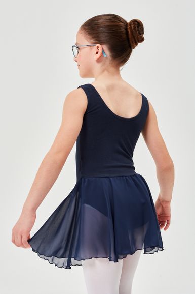 Ein Mädchen in einem marineblauen Ballett Trikot mit einem transparenten Rock steht mit dem Rücken zu mir und blickt leicht nach links.