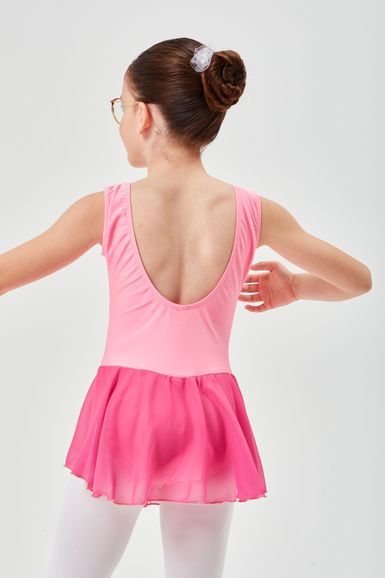 Ein junges Mädchen in einem rosa Ballett Trikot und Rock steht mit dem Rücken zur Kamera