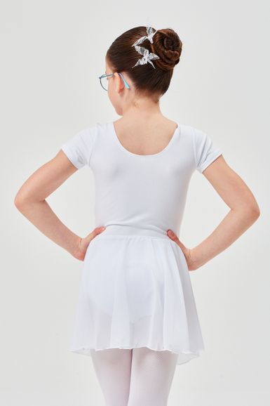 Mädchen in einem weißen Ballett-Outfit mit Dutt und dekorativen Haarnadeln