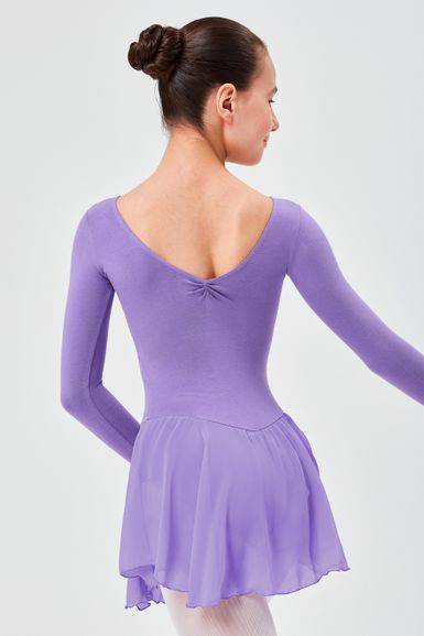 Ein Mädchen in einem lavendelfarbenen Ballettkleid steht mit dem Rücken zur Kamera