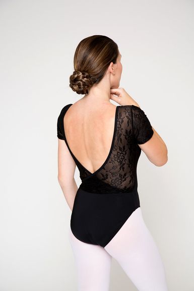 Person in einem schwarzen Spitzenbody und weißen Strumpfhosen