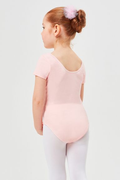 Junges Mädchen in einem hellrosa Trikot und weißen Strumpfhosen