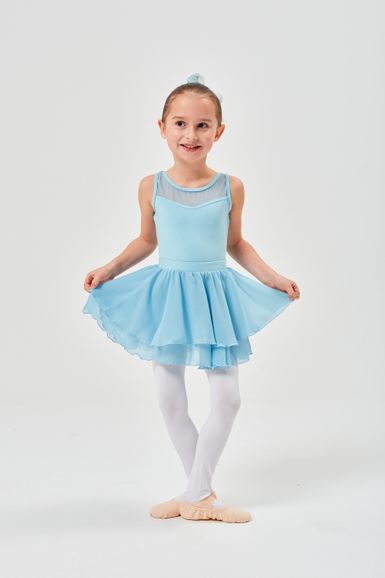 Ein junges Mädchen in einem blauen Ballettkleid und weißen Strumpfhosen steht in einer Tanzpose.