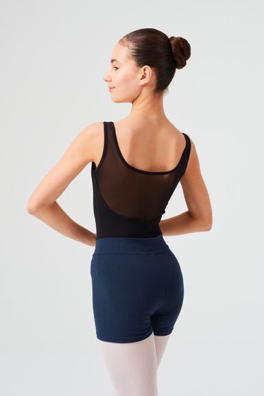 Eine junge Frau in Tanzkleidung steht mit abgewandtem Gesicht