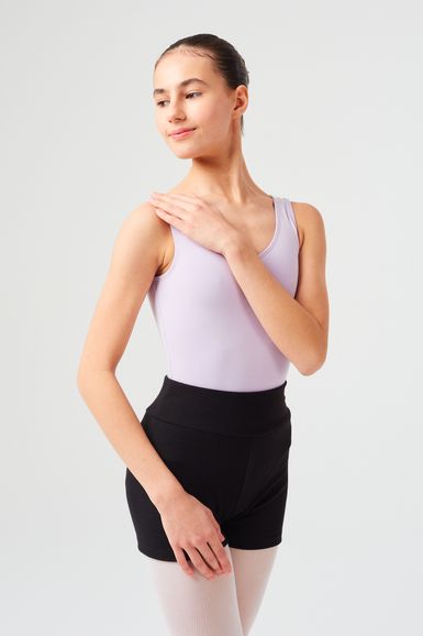 Ein Mädchen in einem lila Ballett Trikot und schwarzen Shorts posiert mit einer Hand auf der Schulter.
