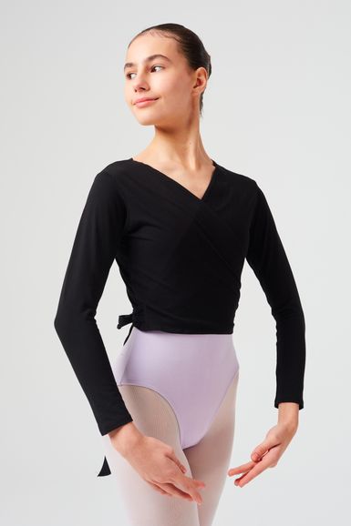 Eine junge Balletttänzerin in einem schwarzen Wickeltop und einem lavendelfarbenen Trikot posiert.