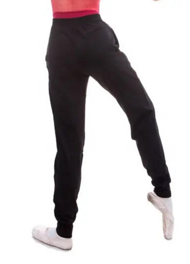Person in schwarzer Jogginghose und weißen Ballettschuhen