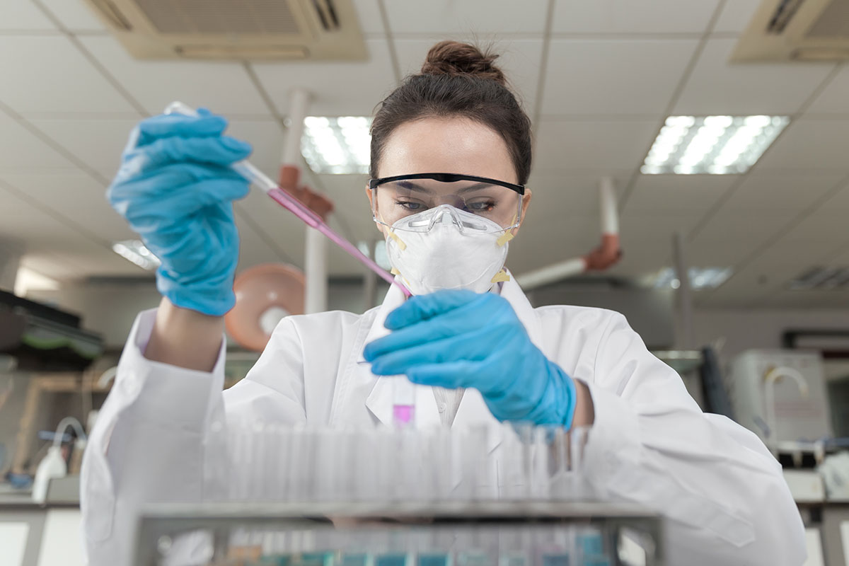Einsatz von Aqua dest im Labor Eine Laborantin füllt bei der Forschung Aqua dest mit einer Pipette in ein Reagenzglas