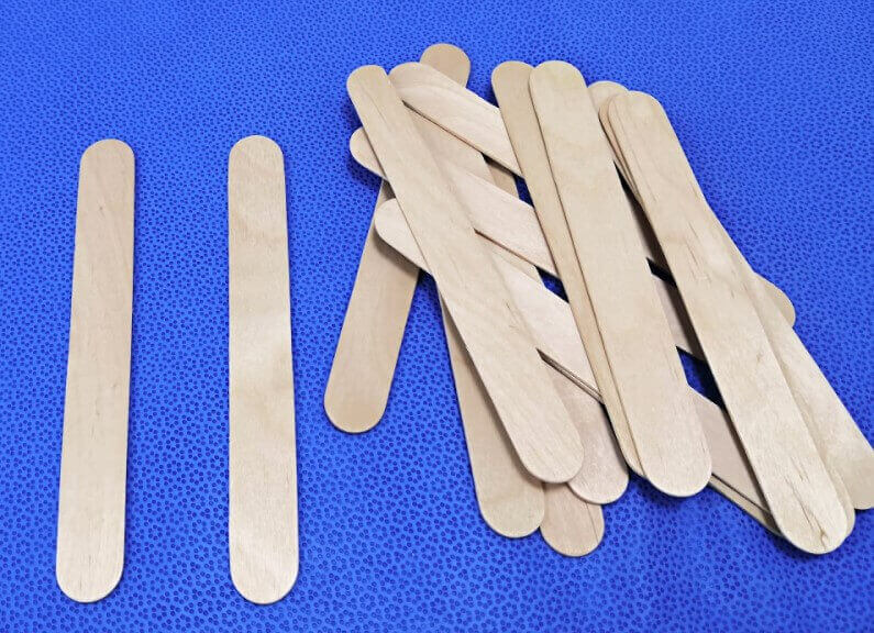 Mundspatel und weitere Einweginstrumente von SANISMART Mundspatel auf einem blauen Tuch stehen stellvertretend für die Kategorie der Einweginstrumente.