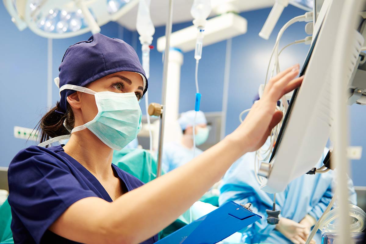 Handpulsoximeter im Krankenhausalltag OP-Schwester arbeitet im Krankenhaus mit Handpulsoximeter und Monitoren