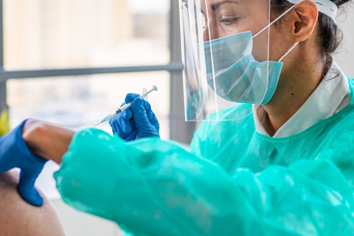 Injektion – geübt mit einem Injektionstrainer Ärztin spritzt Impfstoff – Injektionen hat sie in der Ausbildung mit einem Injektionstrainer geübt
