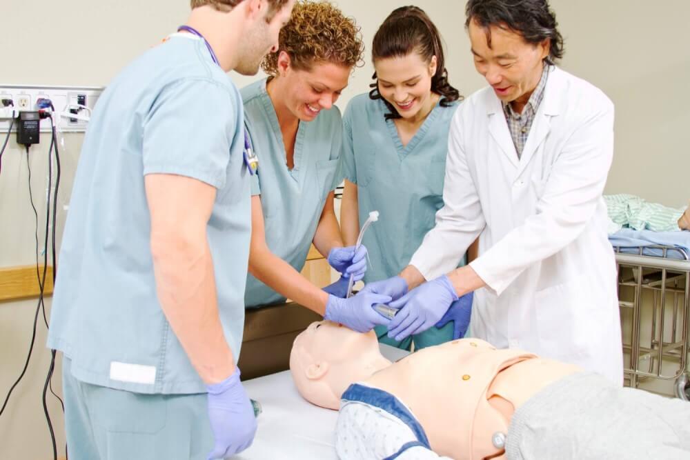 Intubationstraining mit einer medizinischen Übungspuppe Arzt erklärt Studenten die Intubation an einer medizinischen Übungspuppe